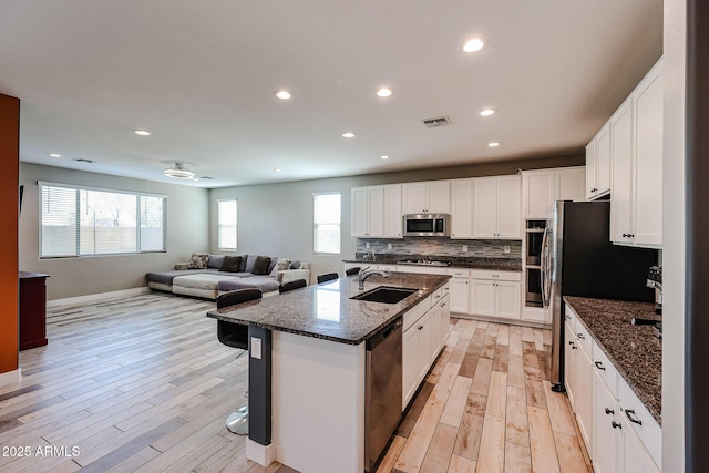 3907 S 75th Dr, Phoenix, AZ 85043 - kitchen featuring a sink, open floor plan, visible vents, light wood-style floors, and appliances with stainless steel finishes