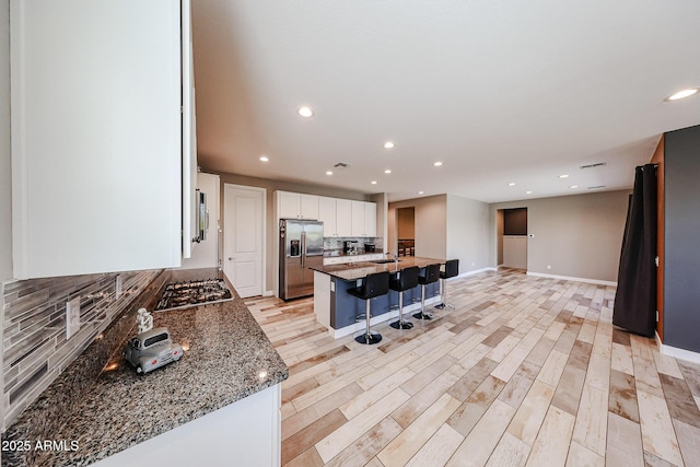 3907 S 75th Dr, Phoenix, AZ 85043 - kitchen with white cabinets, a breakfast bar area, stainless steel appliances, and recessed lighting