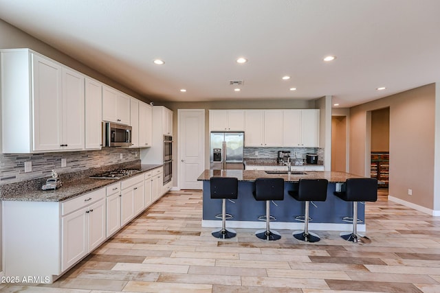 3907 S 75th Dr, Phoenix, AZ 85043 - kitchen with appliances with stainless steel finishes, tasteful backsplash, a sink, and light wood finished floors