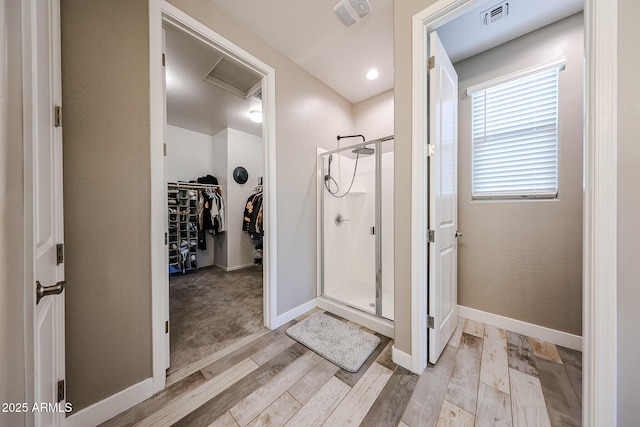 3907 S 75th Dr, Phoenix, AZ 85043 - full bath with a stall shower, baseboards, visible vents, wood finished floors, and a walk in closet