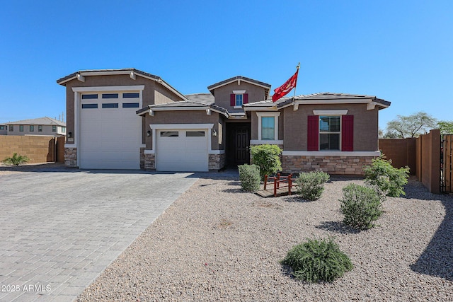 3907 S 75th Dr, Phoenix, AZ 85043 - craftsman inspired home with a tiled roof, stone siding, fence, an attached garage, and decorative driveway