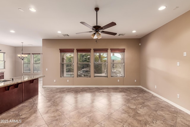 unfurnished living room with sink and ceiling fan with notable chandelier