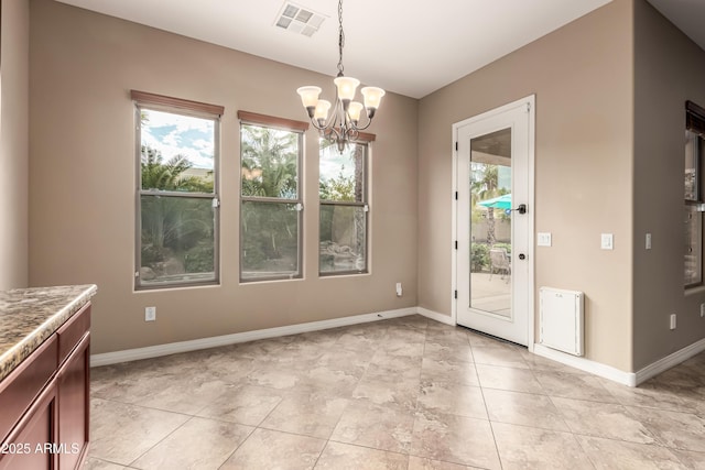 unfurnished dining area featuring light tile patterned floors and a chandelier