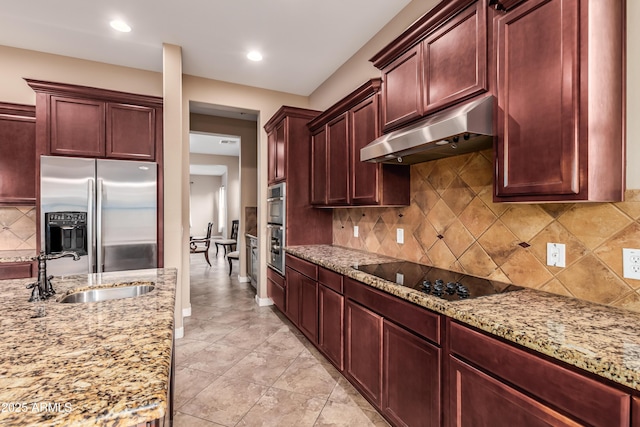 kitchen with light stone countertops, appliances with stainless steel finishes, decorative backsplash, sink, and light tile patterned flooring