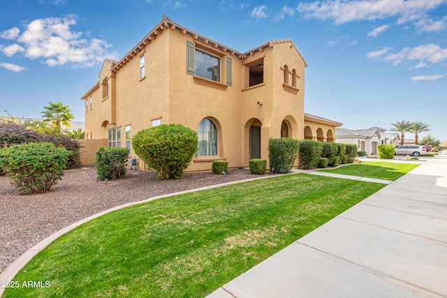 mediterranean / spanish home featuring a front lawn