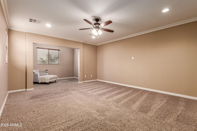 carpeted empty room with ceiling fan and crown molding