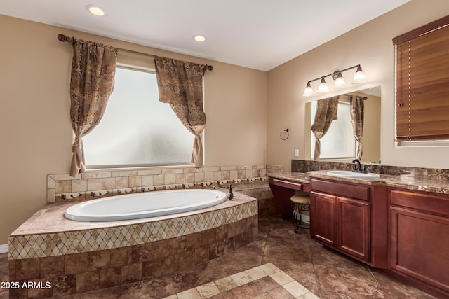 bathroom featuring vanity and tiled bath