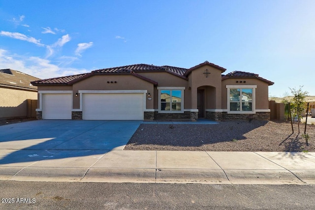 mediterranean / spanish home with an attached garage, stone siding, and stucco siding