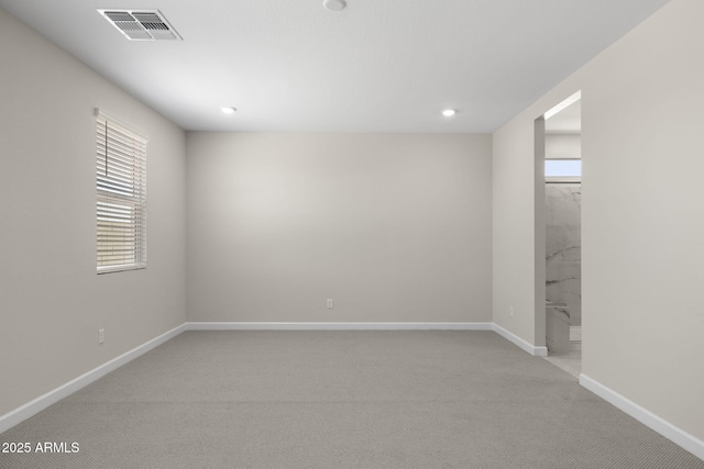 basement featuring light colored carpet, visible vents, baseboards, and recessed lighting