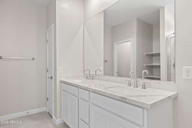 full bathroom with a sink, baseboards, and double vanity