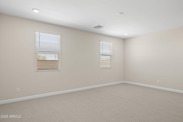 empty room with light carpet, visible vents, and baseboards