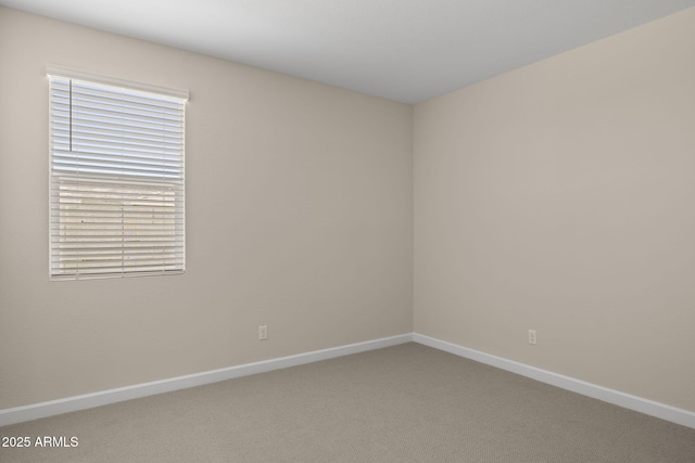 carpeted empty room featuring baseboards