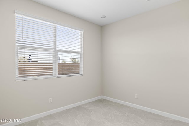 unfurnished room featuring baseboards