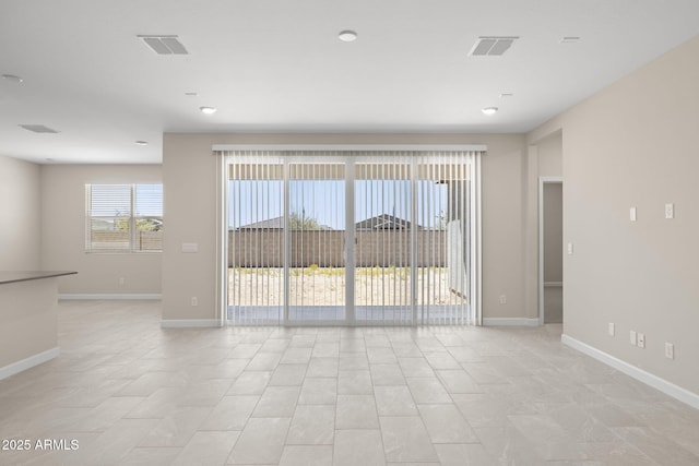 unfurnished room featuring visible vents and baseboards