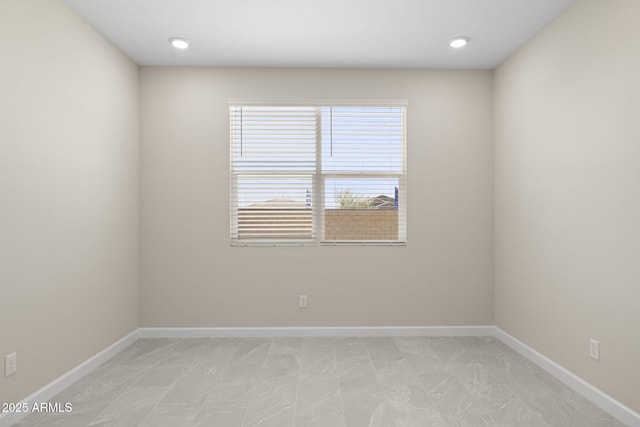 spare room with recessed lighting and baseboards