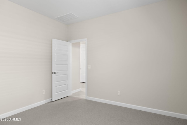 empty room featuring baseboards, visible vents, and carpet flooring