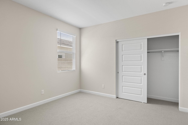 unfurnished bedroom with carpet floors, a closet, and baseboards