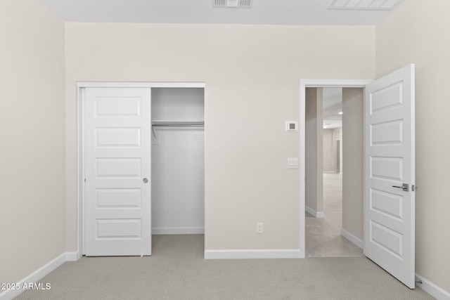 unfurnished bedroom featuring light carpet, baseboards, visible vents, and a closet