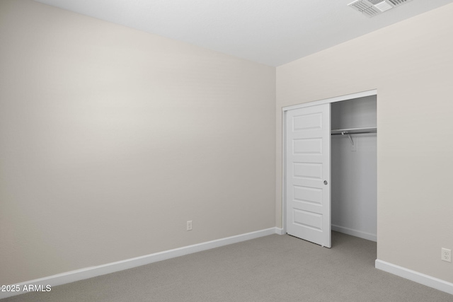 unfurnished bedroom featuring baseboards, a closet, visible vents, and light colored carpet