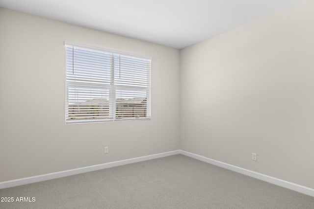 unfurnished room featuring light carpet and baseboards