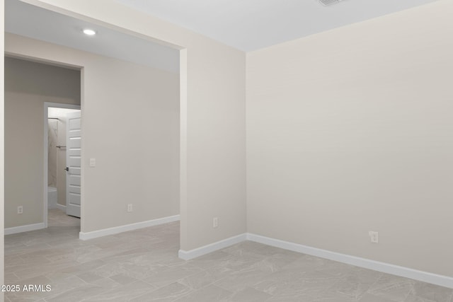 empty room featuring baseboards and recessed lighting