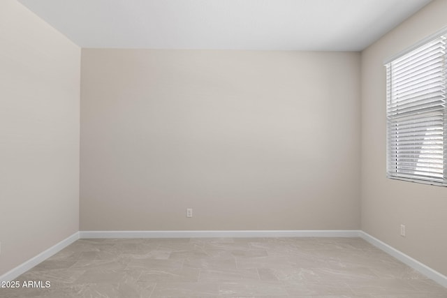 unfurnished room with baseboards