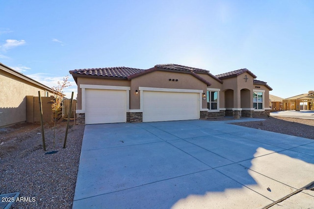 mediterranean / spanish home with an attached garage, stone siding, a tiled roof, driveway, and stucco siding