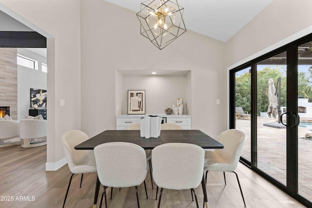 dining area with a healthy amount of sunlight, light hardwood / wood-style flooring, and a premium fireplace