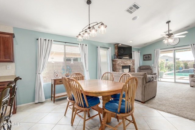 dining room with a fireplace, visible vents, ceiling fan, and plenty of natural light