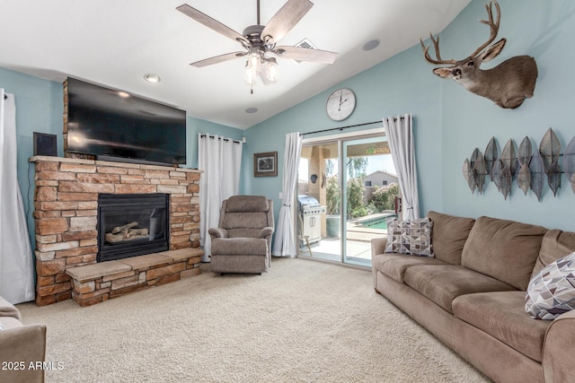 carpeted living room with a ceiling fan, a stone fireplace, and lofted ceiling