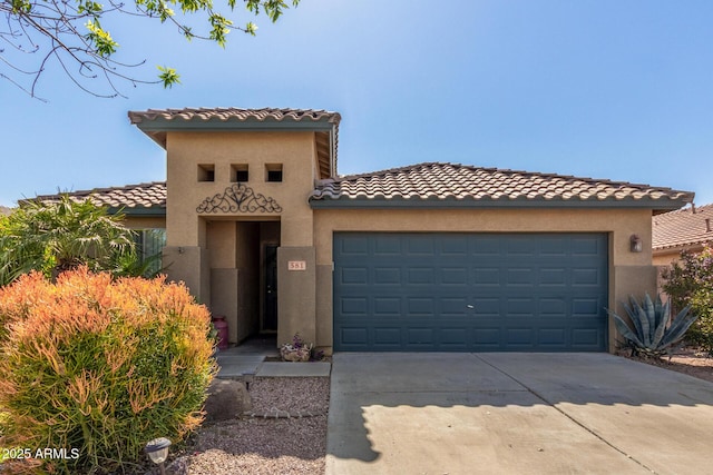 mediterranean / spanish-style home with a tile roof, concrete driveway, and a garage
