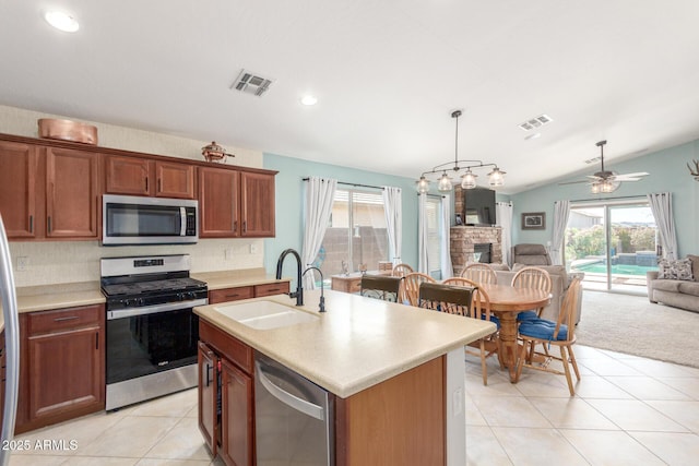 kitchen featuring light countertops, a sink, appliances with stainless steel finishes, open floor plan, and visible vents