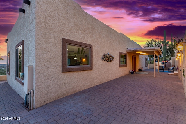 property exterior at dusk featuring a patio