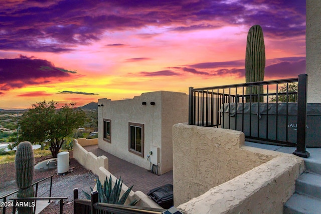 property exterior at dusk featuring a balcony