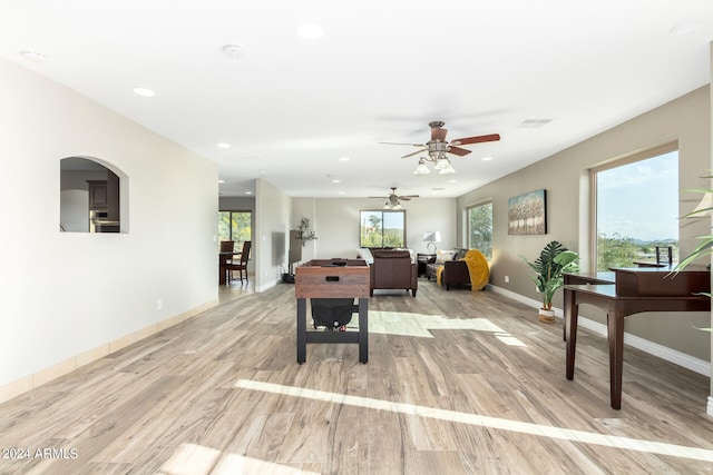 dining space with ceiling fan and light wood-type flooring