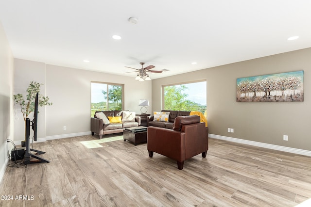 living room with light hardwood / wood-style flooring and ceiling fan