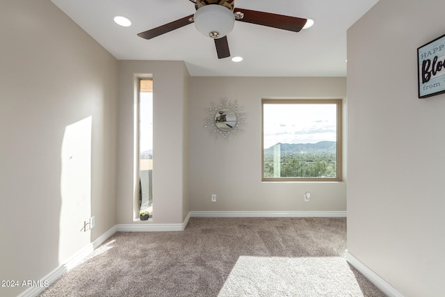 carpeted empty room with plenty of natural light and ceiling fan