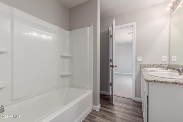 255 W Dewey Ave, Coolidge, AZ 85128 - full bathroom with wood finished floors, double vanity, baseboards, and tub / shower combination