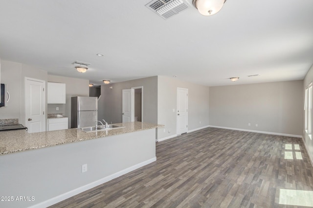 255 W Dewey Ave, Coolidge, AZ 85128 - kitchen featuring freestanding refrigerator, a sink, white cabinets, and dark wood-type flooring