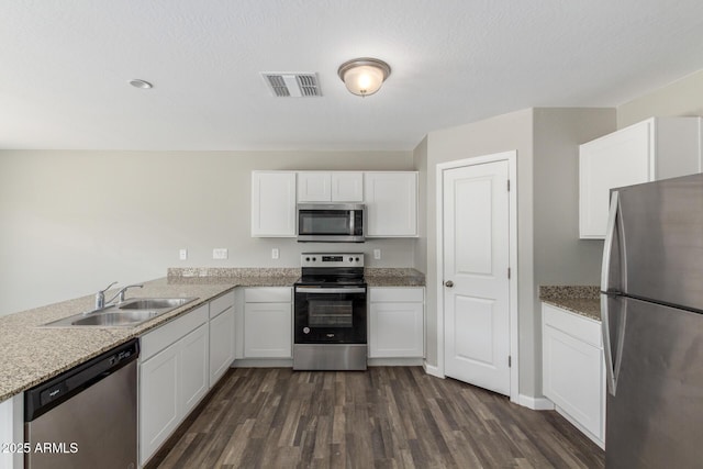 255 W Dewey Ave, Coolidge, AZ 85128 - kitchen featuring stainless steel appliances, a sink, dark wood-type flooring, white cabinetry, and light stone countertops