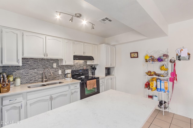 kitchen with sink, black appliances, tasteful backsplash, light tile patterned floors, and white cabinets