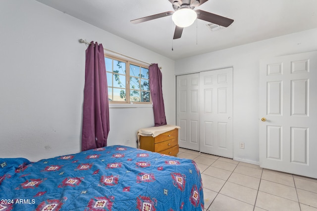 bedroom with a closet, light tile patterned floors, and ceiling fan