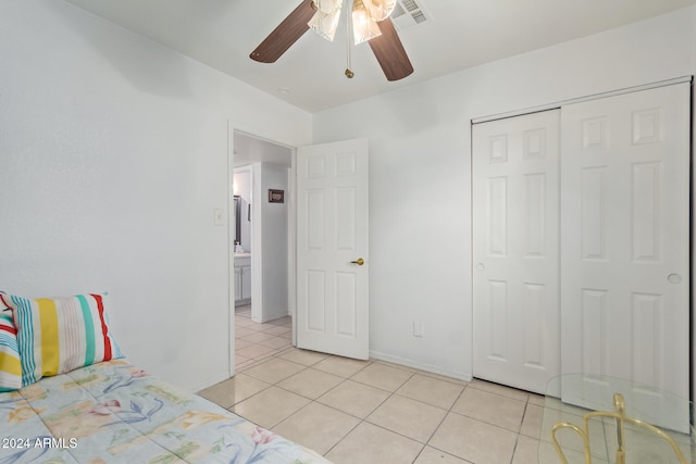 unfurnished bedroom with a closet, light tile patterned floors, and ceiling fan