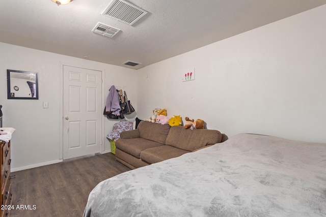 bedroom featuring a textured ceiling and dark hardwood / wood-style floors