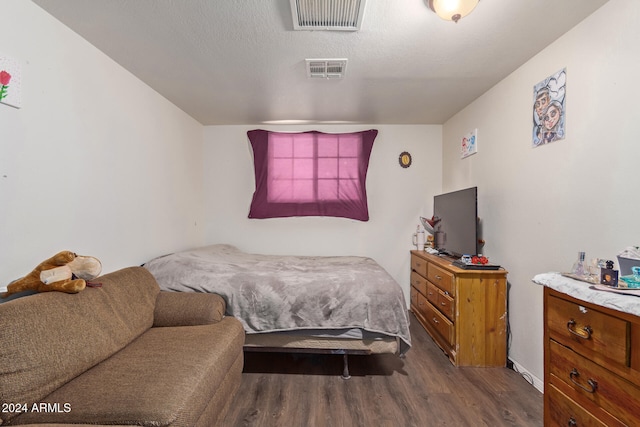 bedroom featuring hardwood / wood-style floors and a textured ceiling