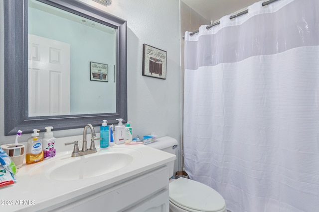 bathroom with toilet, vanity, and walk in shower