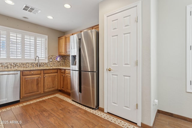 4718 E Woburn Ln, Cave Creek, AZ 85331 - kitchen with appliances with stainless steel finishes, recessed lighting, tasteful backsplash, a sink, and brown cabinetry