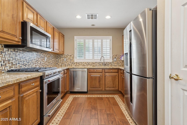 4718 E Woburn Ln, Cave Creek, AZ 85331 - kitchen with stainless steel appliances, brown cabinetry, and recessed lighting