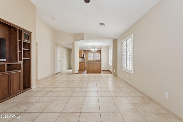 4718 E Woburn Ln, Cave Creek, AZ 85331 - unfurnished living room with a chandelier, vaulted ceiling, light tile patterned flooring, and baseboards