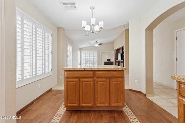 4718 E Woburn Ln, Cave Creek, AZ 85331 - kitchen featuring a chandelier, arched walkways, light wood-style flooring, light countertops, and lofted ceiling
